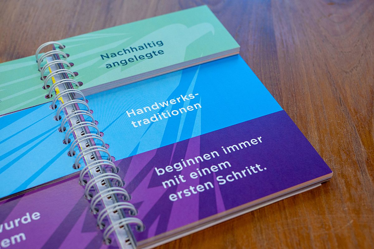 Klappbuch-Seite: „Nachhaltig angelegte Handwerkstraditionen beginnen immer mit einem ersten Schritt.“