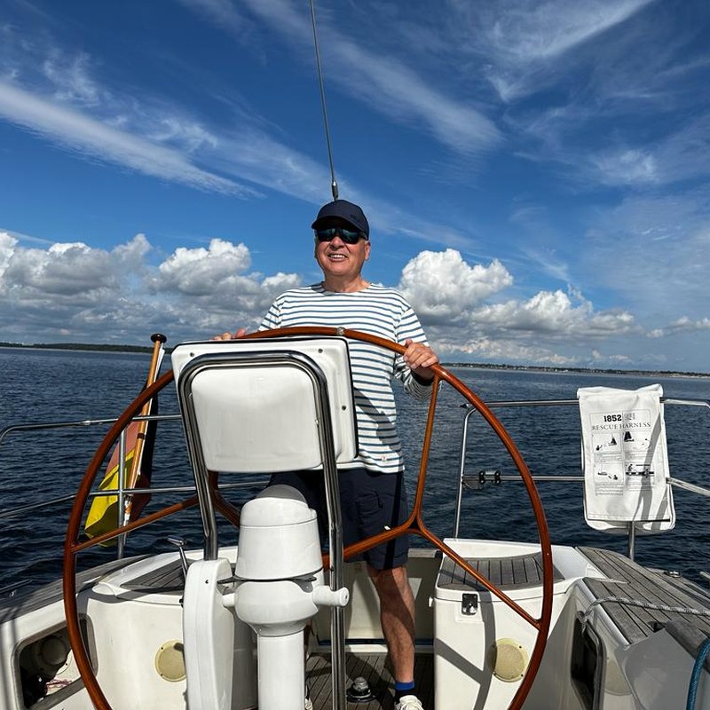 Porträt Andreas Grosz am Ruder eines Segelboots